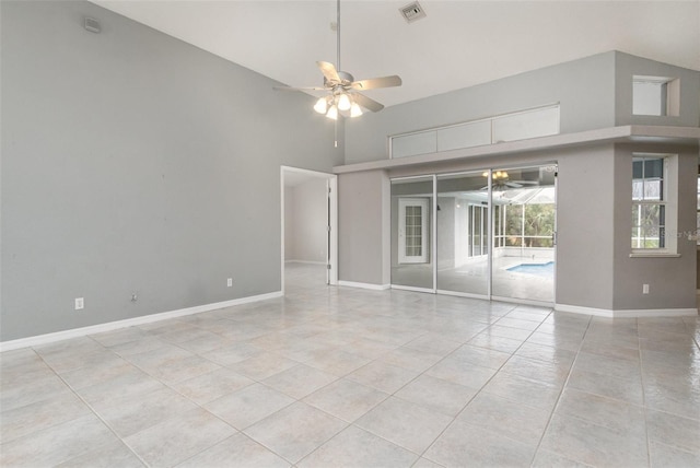 empty room featuring ceiling fan, high vaulted ceiling, and light tile patterned floors