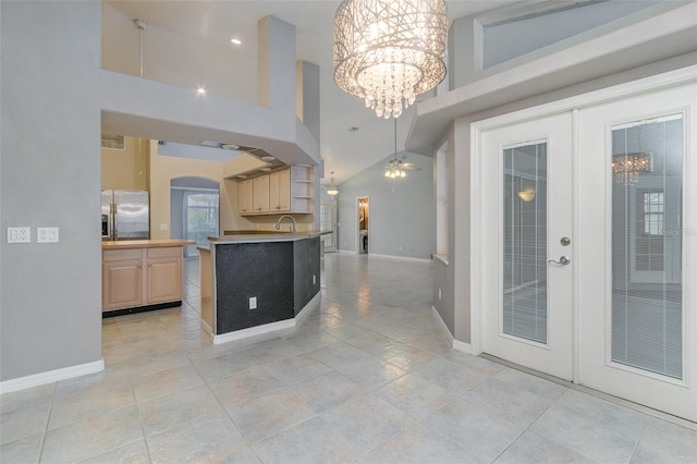 kitchen featuring sink, high vaulted ceiling, stainless steel fridge with ice dispenser, french doors, and light brown cabinets