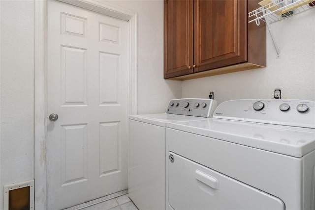 laundry area featuring cabinets, separate washer and dryer, and light tile patterned floors