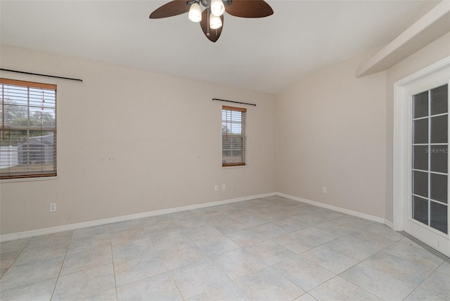 unfurnished room featuring vaulted ceiling, plenty of natural light, light tile patterned floors, and ceiling fan