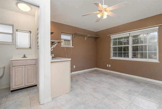 tiled spare room with ceiling fan, a healthy amount of sunlight, and sink