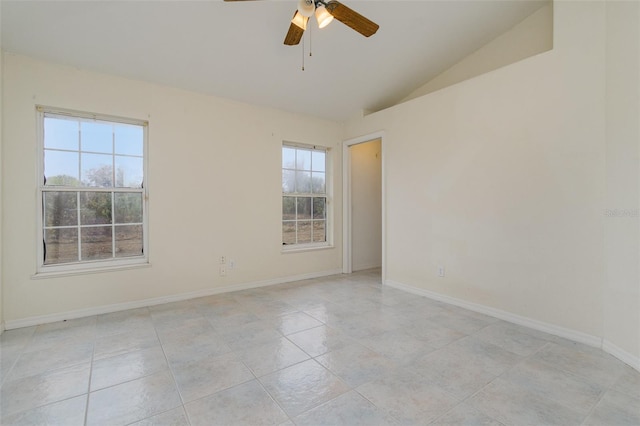 spare room with vaulted ceiling, plenty of natural light, light tile patterned floors, and ceiling fan