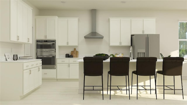 kitchen featuring white fridge with ice dispenser, wall chimney range hood, white cabinets, and double oven