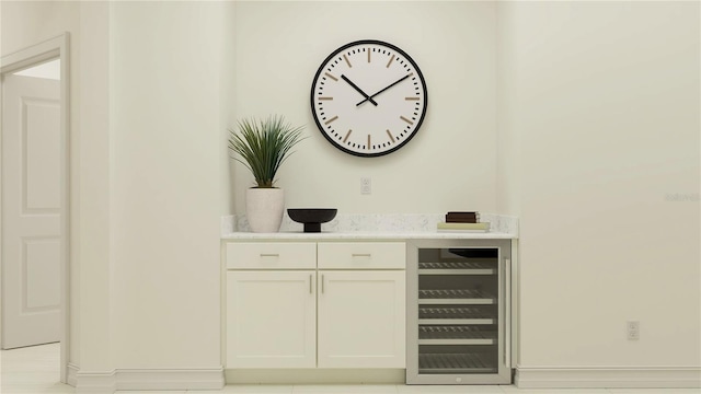 bar with wine cooler and white cabinetry