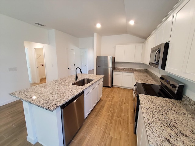 kitchen with sink, white cabinetry, a center island with sink, appliances with stainless steel finishes, and light stone countertops