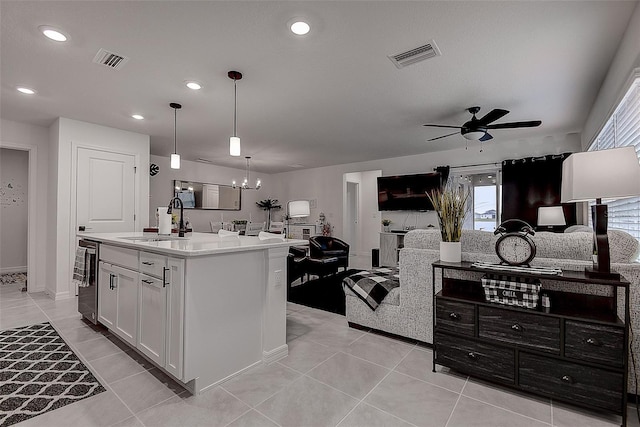 kitchen with sink, white cabinetry, decorative light fixtures, an island with sink, and ceiling fan with notable chandelier