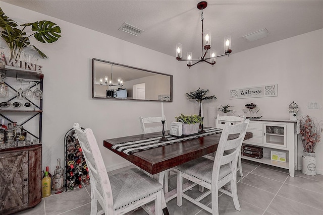 dining space featuring tile patterned flooring, a textured ceiling, and an inviting chandelier