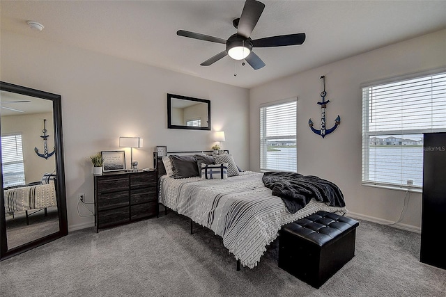 bedroom featuring multiple windows, light colored carpet, and ceiling fan