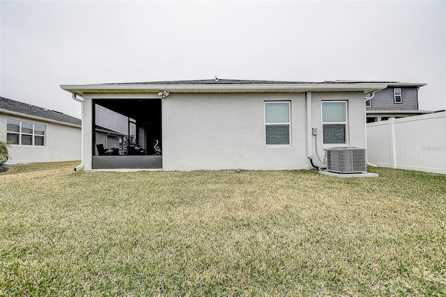 back of house with a yard, a sunroom, and central air condition unit