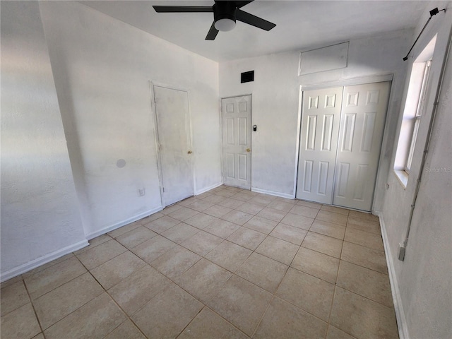 unfurnished bedroom with ceiling fan, a closet, and light tile patterned floors