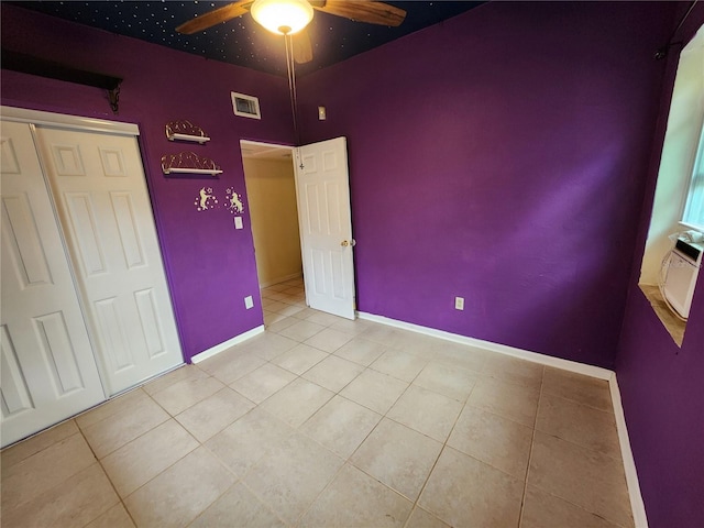 unfurnished bedroom featuring a closet, ceiling fan, and light tile patterned flooring