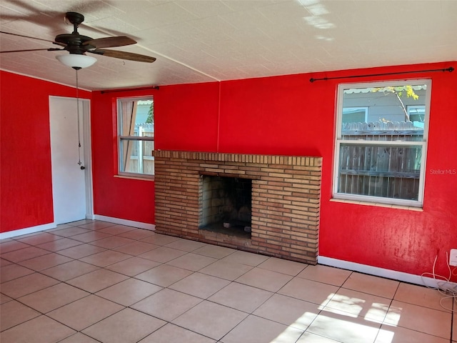 unfurnished living room with light tile patterned flooring, ceiling fan, and a fireplace