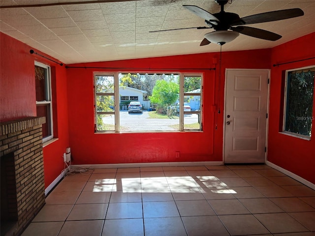 interior space featuring lofted ceiling, light tile patterned floors, and ceiling fan