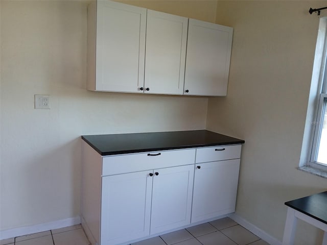 kitchen with light tile patterned flooring and white cabinets