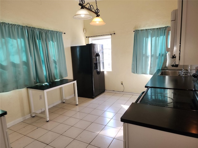 kitchen with light tile patterned floors, sink, hanging light fixtures, and black appliances