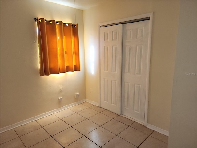 unfurnished bedroom featuring a closet and light tile patterned floors