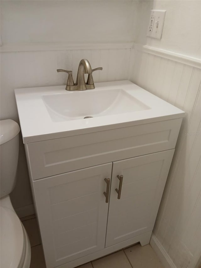 bathroom featuring tile patterned flooring, vanity, and toilet