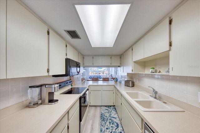 kitchen with sink, white cabinets, backsplash, white electric range oven, and light wood-type flooring