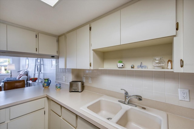 kitchen with white cabinetry, sink, and backsplash