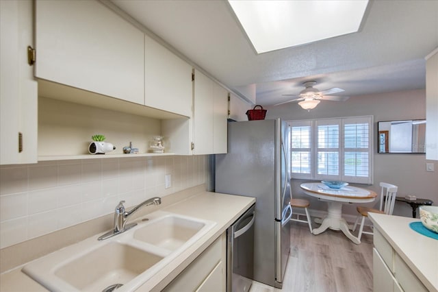 kitchen with tasteful backsplash, sink, white cabinetry, and dishwasher