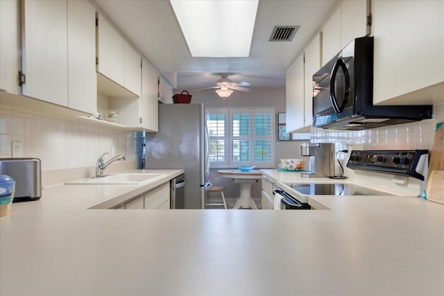 kitchen with sink, white cabinetry, appliances with stainless steel finishes, ceiling fan, and backsplash