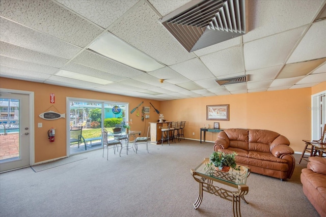 carpeted living room with a paneled ceiling and plenty of natural light