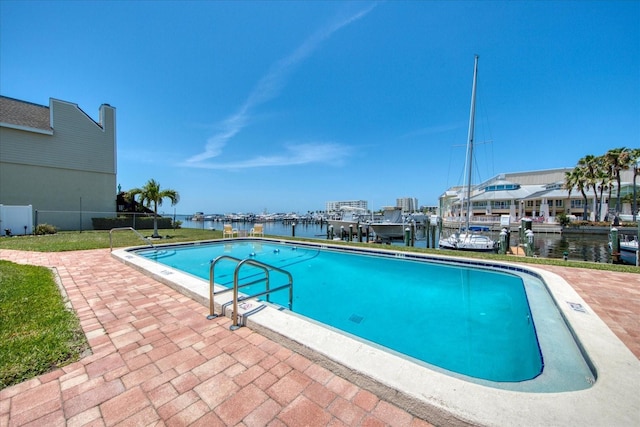 view of pool featuring a water view and a yard