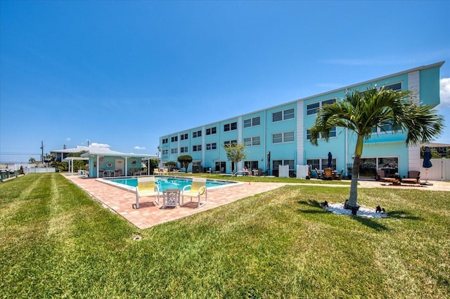 view of pool with a patio and a lawn