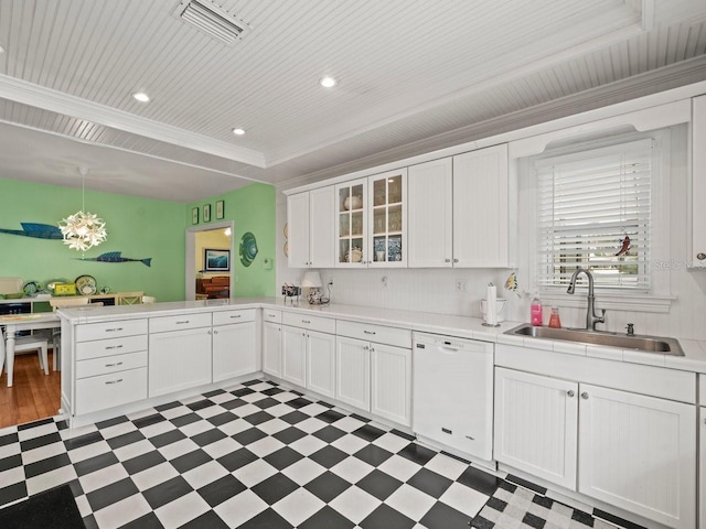 kitchen featuring white dishwasher, sink, white cabinetry, and decorative light fixtures