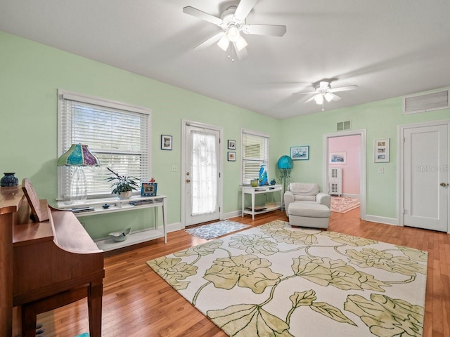 interior space with ceiling fan and wood-type flooring