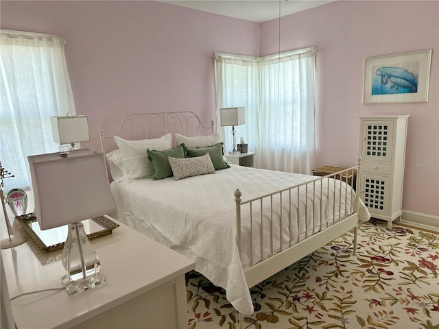 bedroom featuring baseboards and multiple windows