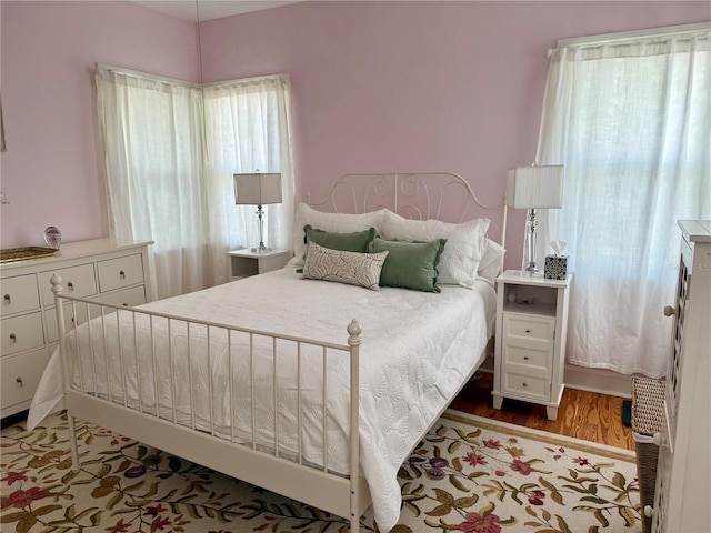 bedroom featuring multiple windows and wood finished floors