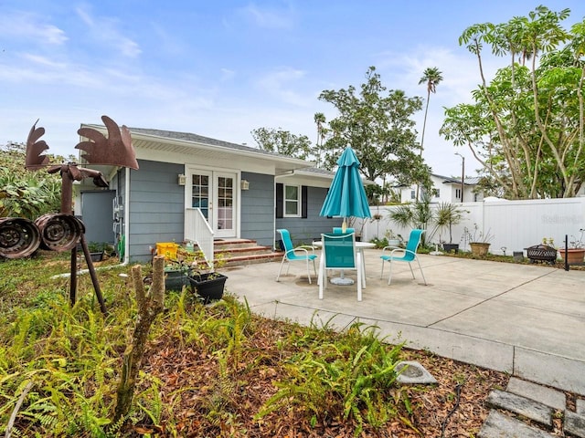 rear view of house with a patio, fence, and entry steps