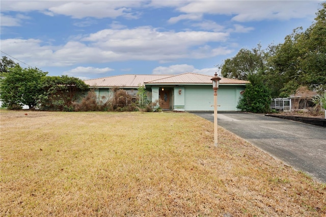 ranch-style house featuring a garage and a front lawn