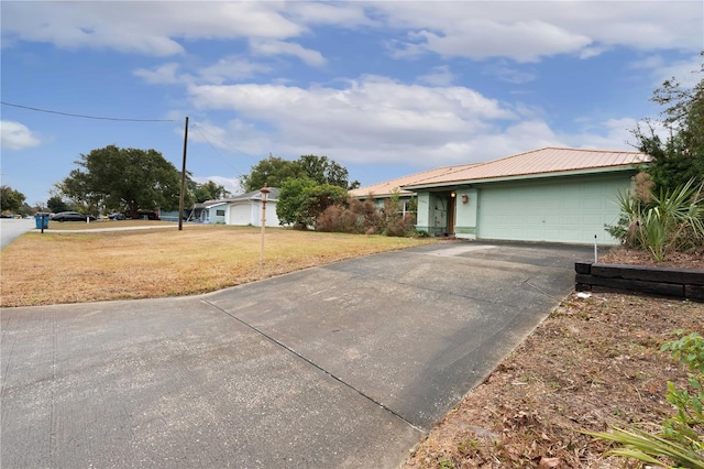 ranch-style home featuring a garage and a front lawn