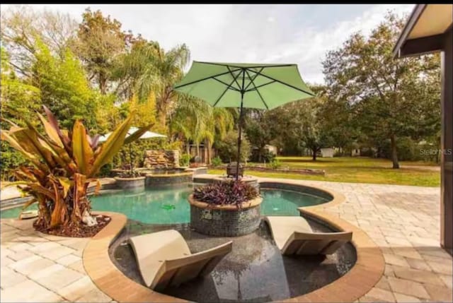 view of pool featuring a patio and an in ground hot tub