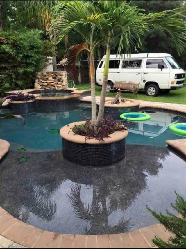 view of pool with an in ground hot tub