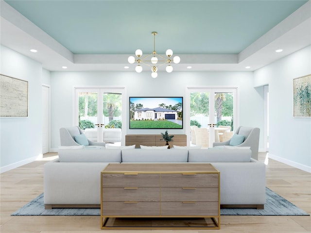 living room with plenty of natural light, a tray ceiling, and french doors