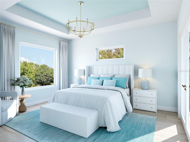 bedroom featuring light wood-type flooring, a raised ceiling, multiple windows, and an inviting chandelier