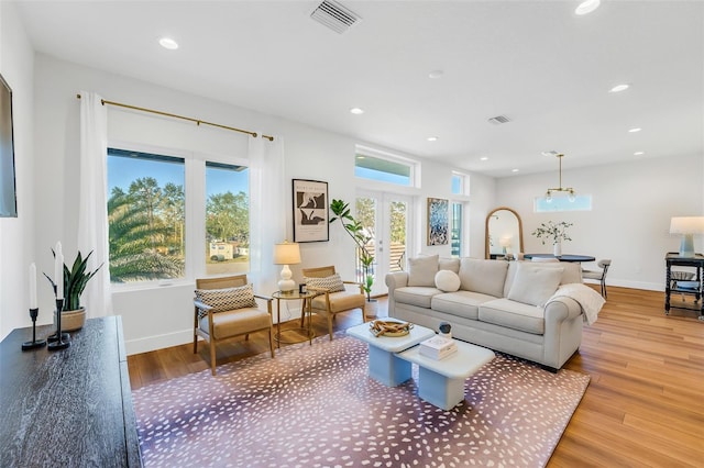 living room with french doors and light wood-type flooring