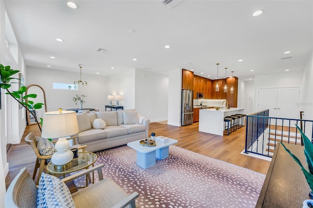 living room with sink and light wood-type flooring