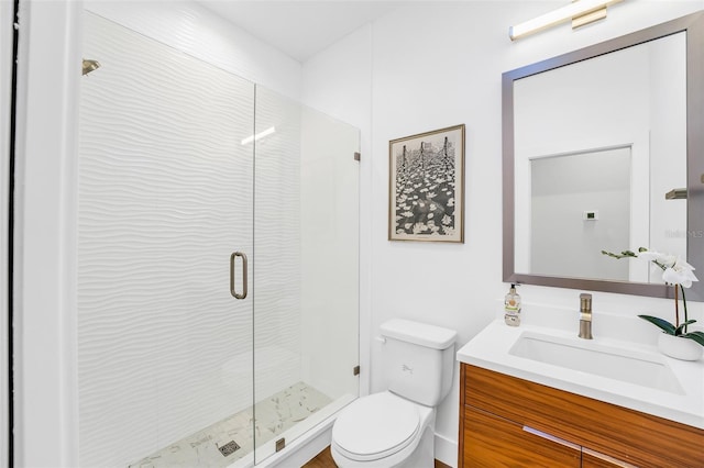 bathroom with vanity, a shower with shower door, and toilet