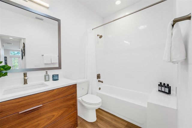 full bathroom featuring hardwood / wood-style flooring, shower / tub combination, vanity, and toilet