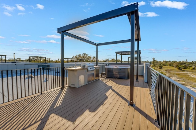 wooden terrace with a hot tub and area for grilling