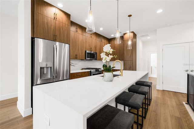 460 87th Ave N, Saint Petersburg, FL 33702 - kitchen featuring a sink, appliances with stainless steel finishes, brown cabinetry, and light wood finished floors