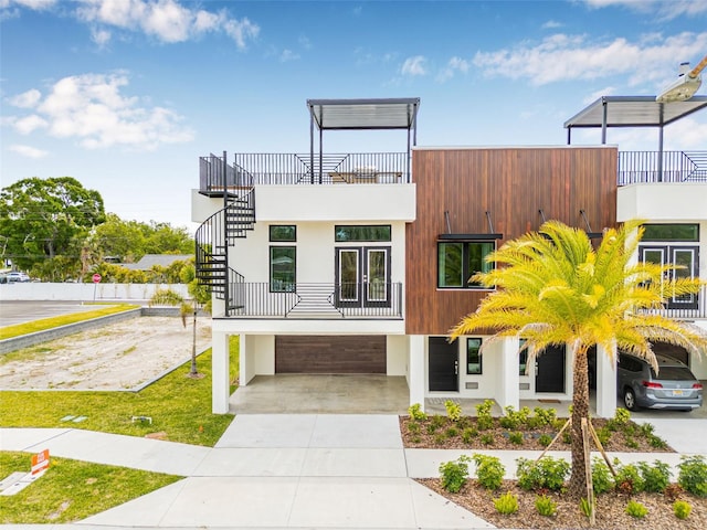 460 87th Ave N, Saint Petersburg, FL 33702 - view of front of property with a balcony, an attached garage, concrete driveway, stairway, and stucco siding