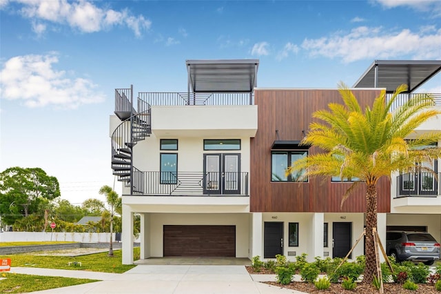 460 87th Ave N, Saint Petersburg, FL 33702 - view of front of property with a balcony, an attached garage, stairway, stucco siding, and driveway