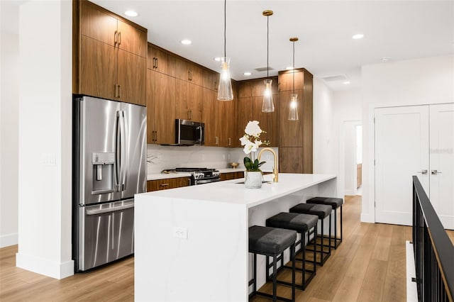 460 87th Ave N, Saint Petersburg, FL 33702 - kitchen with light wood finished floors, backsplash, a kitchen bar, and stainless steel appliances