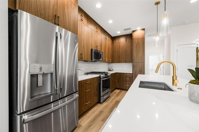 460 87th Ave N, Saint Petersburg, FL 33702 - kitchen with visible vents, appliances with stainless steel finishes, a sink, light wood-style floors, and backsplash