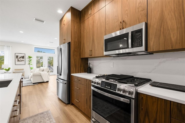 460 87th Ave N, Saint Petersburg, FL 33702 - kitchen featuring open floor plan, visible vents, appliances with stainless steel finishes, and decorative backsplash